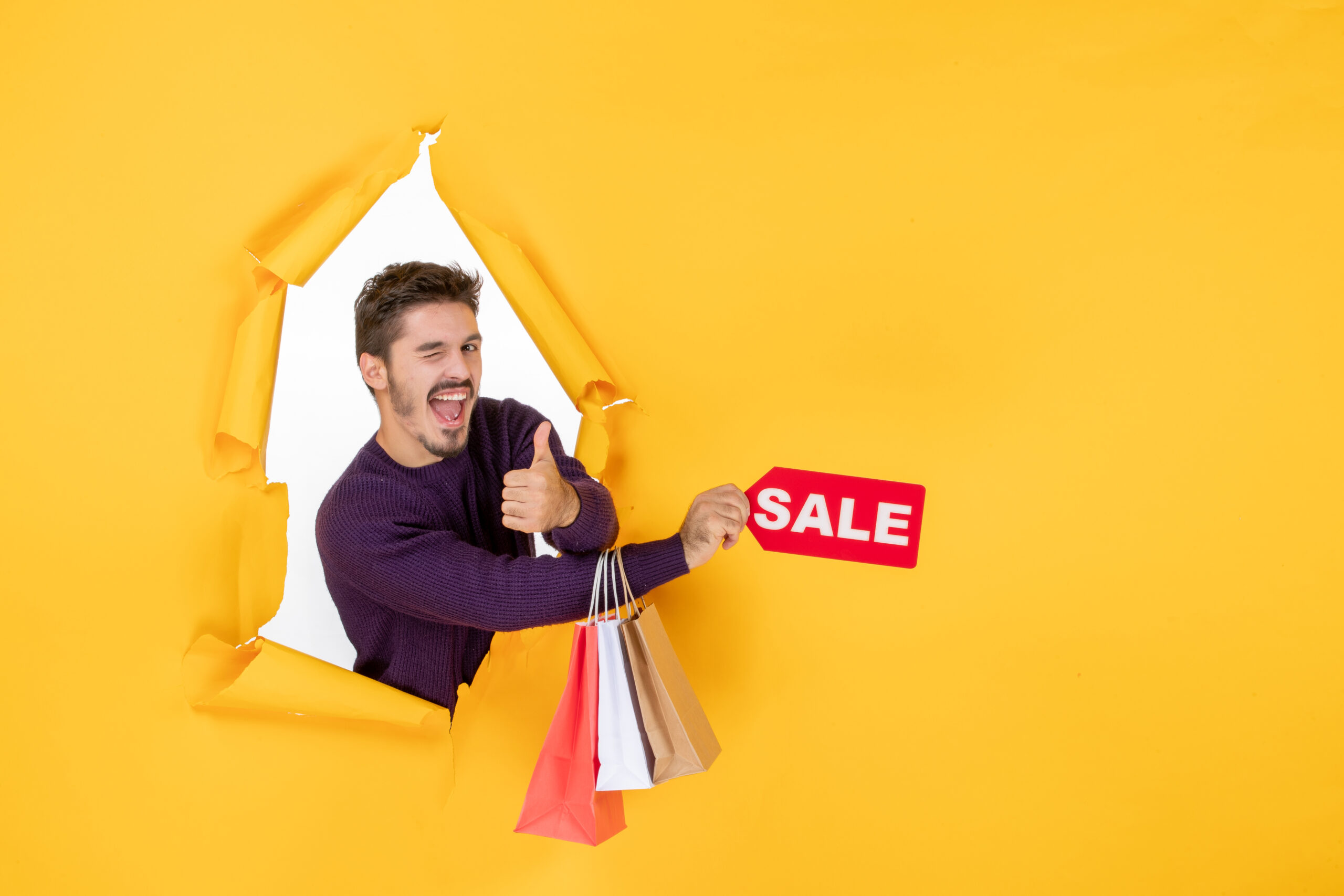 Image of a man displaying a Sales sign or promoting a sales promotion